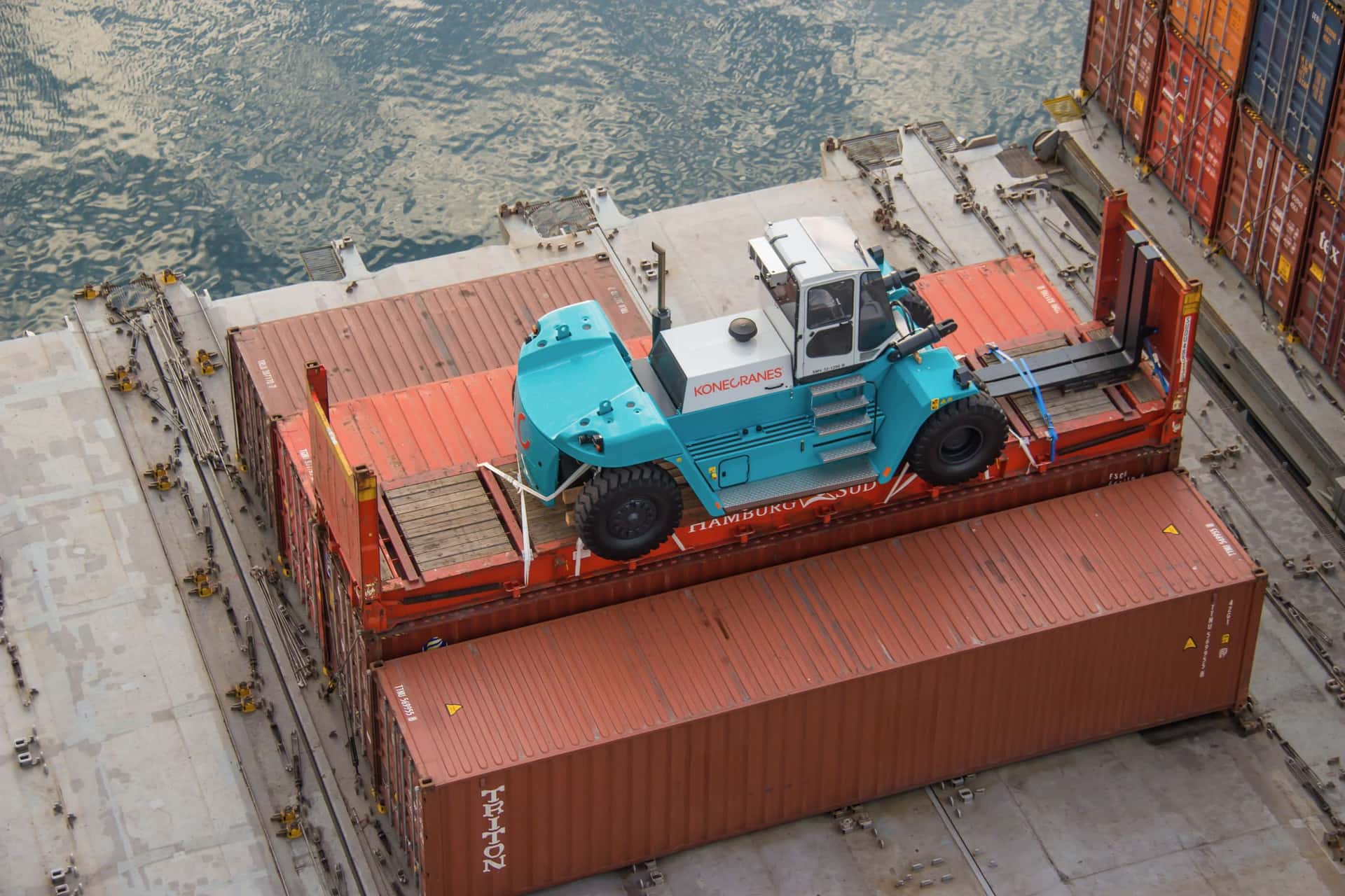 A forklift lashed to a 40-foot flat rack on the deck of a vessel in the Port of Helsingborg
