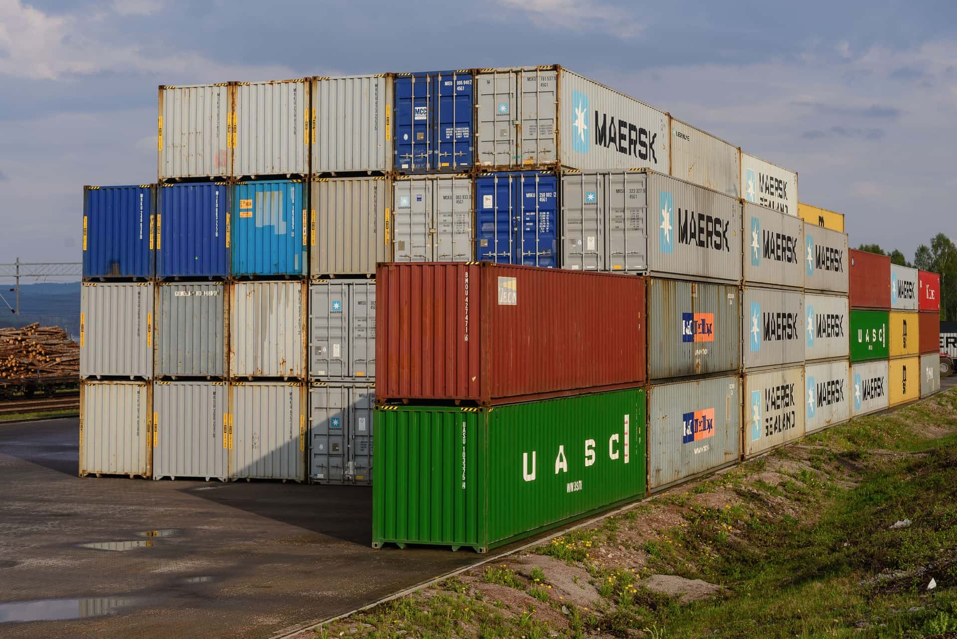 Stacked 40-foot high cube containers with height warning stripes on the top rails