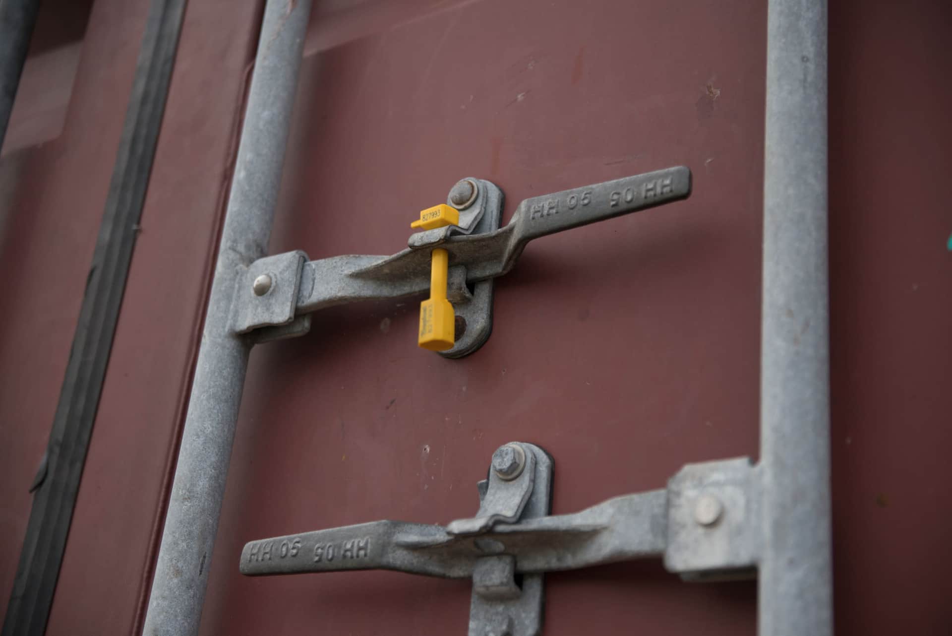 Door locking bars, cam keepers and a yellow bolt seal on a container door