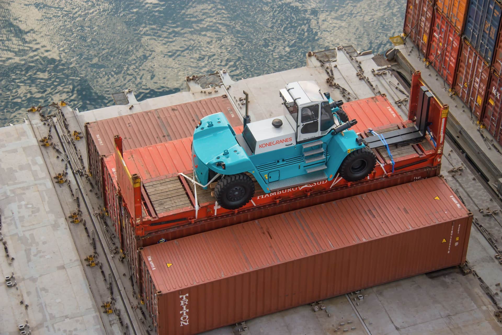 A forklift lashed to a 40-foot flat rack on the deck of a vessel in the Port of Helsingborg
