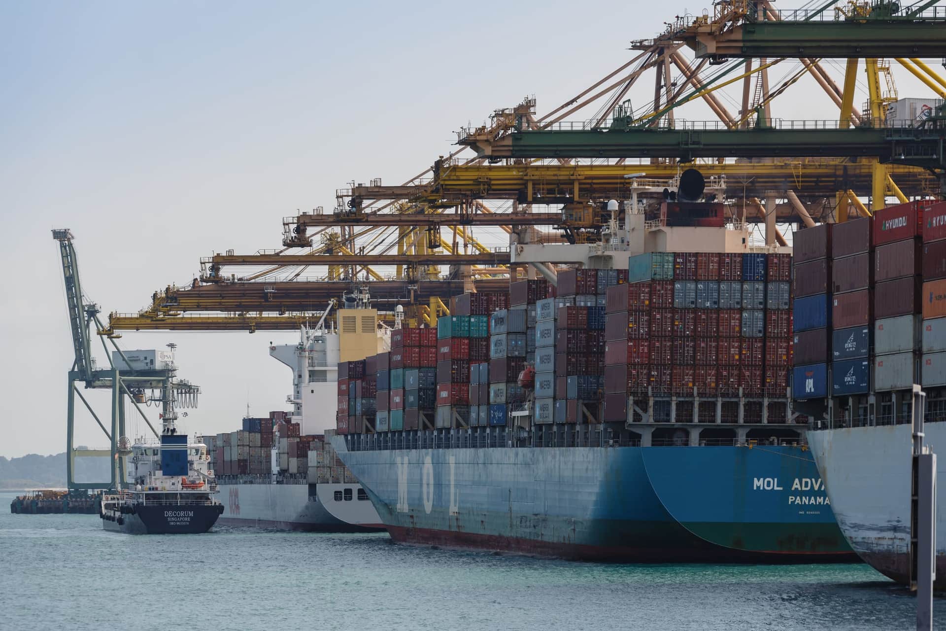 A container ship alongside Pasir Panjang Terminal, Singapore, with quay cranes working over its deck