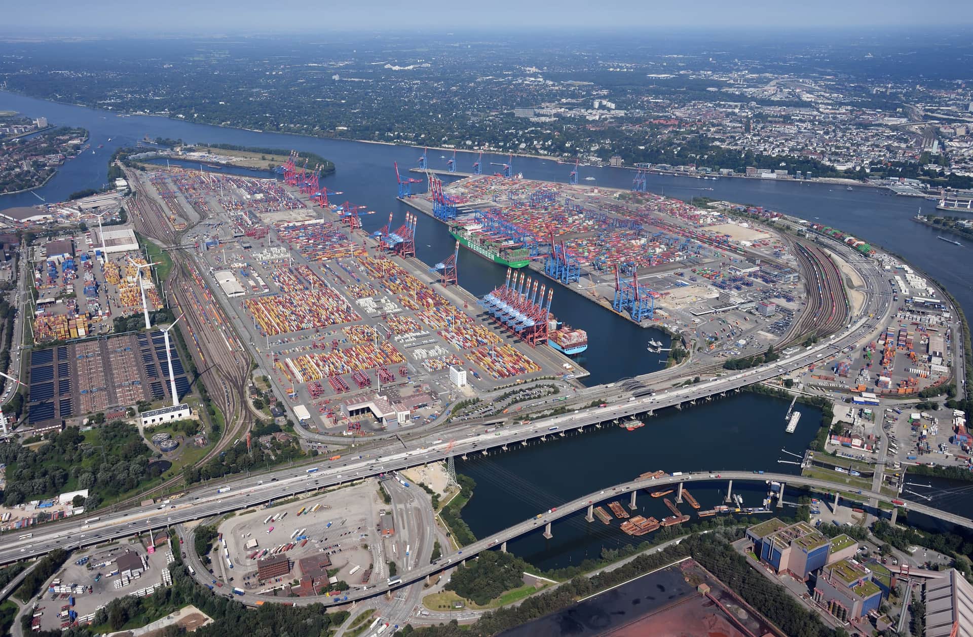 Aerial view of container terminals in the Port of Hamburg with quay cranes, berthed vessels and stacks