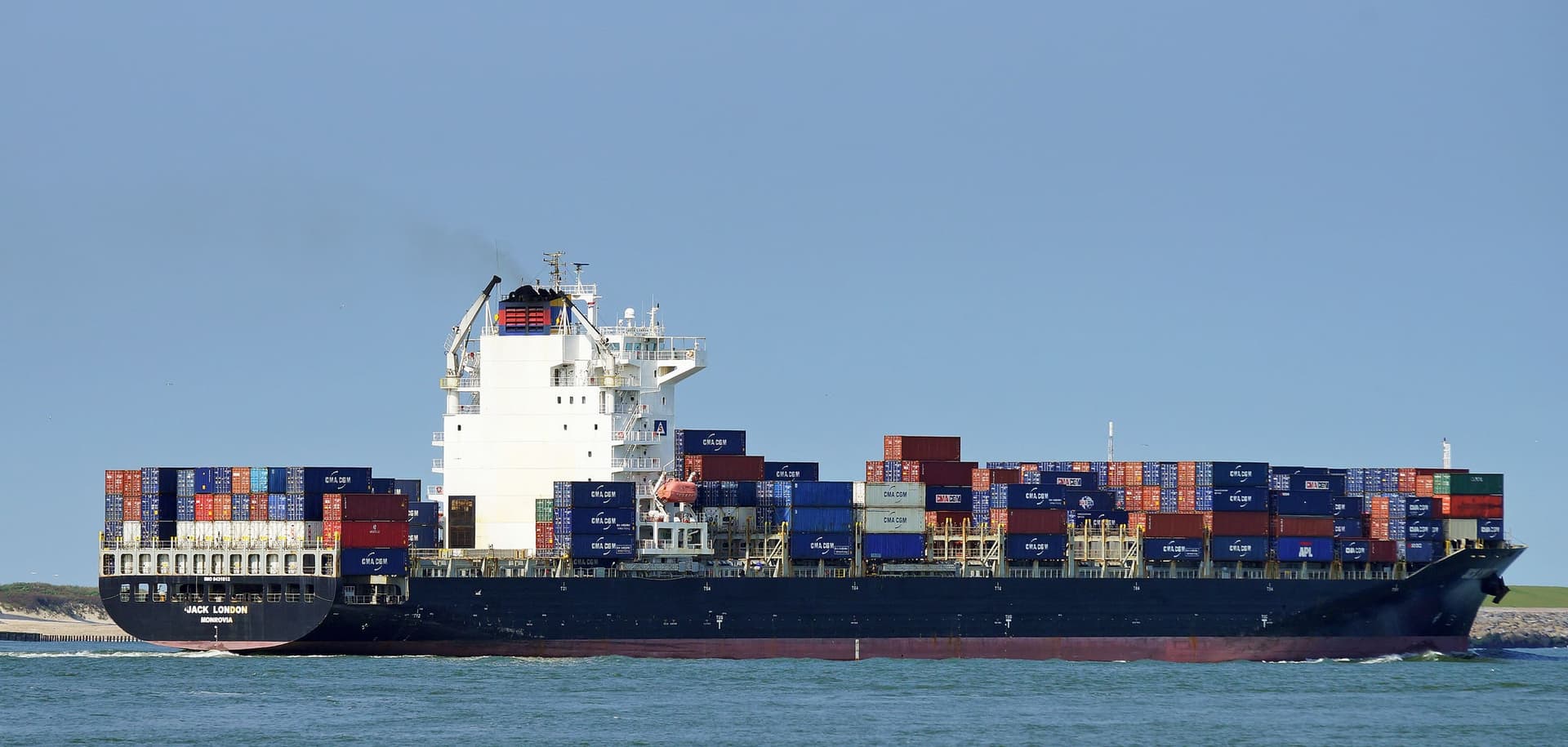 A loaded container ship under way off Rotterdam in clear weather