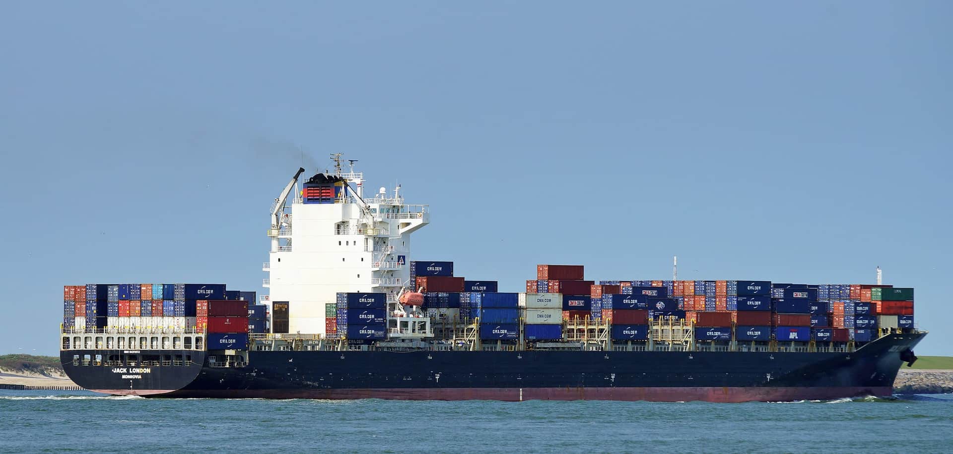 A loaded container ship under way off Rotterdam in clear weather